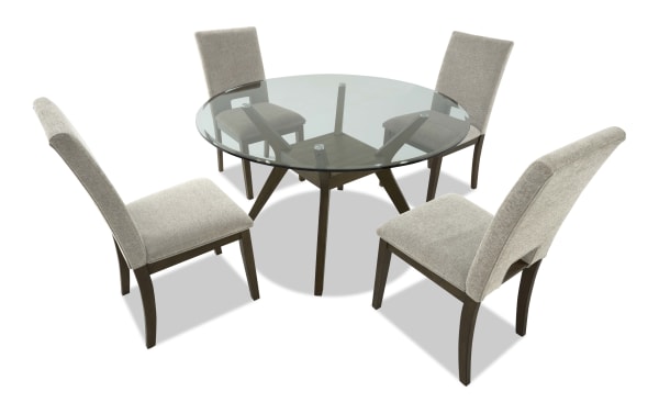 Round glass dining table with dark wood base and four beige upholstered chairs, modern style for home or office dining room.