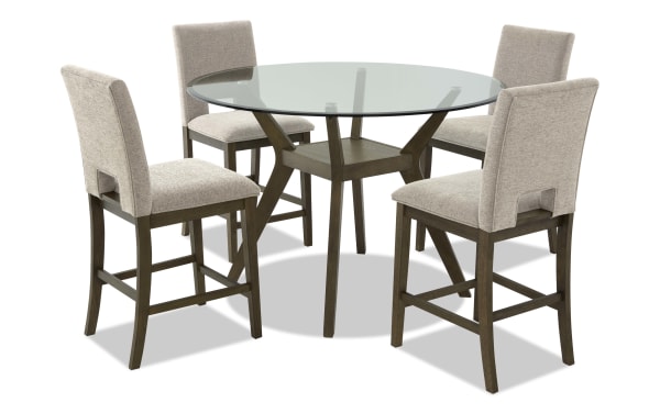 Round glass-top dining table set with four beige upholstered chairs, featuring wooden legs and modern design for kitchen or dining room.
