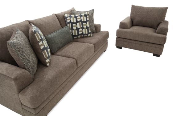 Brown fabric sofa and armchair set with plush cushions and patterned throw pillows, showcasing modern, comfortable living room furniture.