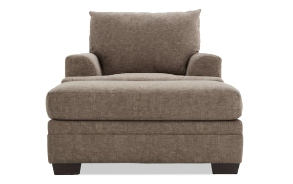 Brown fabric upholstered armchair with wide cushioned seat, padded arms, and supportive backrest, featuring dark wooden block legs.