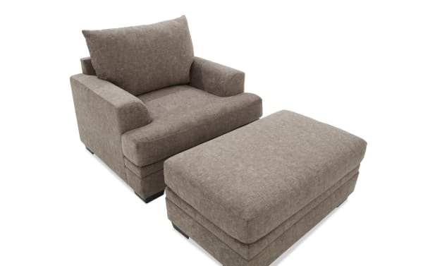 Brown upholstered armchair with matching ottoman, featuring soft fabric, cushioned seat and backrest, ideal for living room comfort.