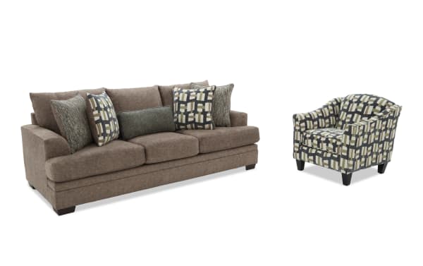 Brown fabric sofa with three seat cushions and multiple decorative pillows, paired with a patterned armchair featuring geometric designs in beige, black, and gray.
