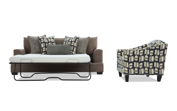 Brown fabric sofa bed with geometric patterned throw pillows and a white mattress, next to a matching geometric patterned armchair with dark wooden legs.