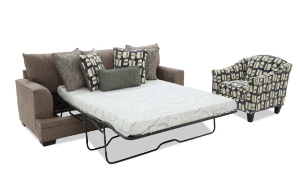 Brown fabric sofa bed with geometric patterned cushions and a white mattress, paired with a matching patterned armchair.