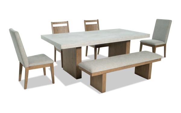 Monterey 6 Piece Natural & Gray Upholstered Dining Set with Bench features a faux concrete melamine table top, four gray polyester fabric chairs with rubberwood frames, and a matching bench. Traditional style with moisture and heat-resistant finish, ideal for family dining.