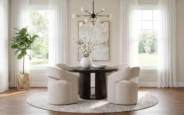 Modern dining room with a round dark wood table, four beige upholstered swivel chairs, a decorative white vase with flowers, large windows with sheer curtains, a circular patterned rug, and a green potted plant.