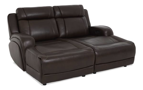 Dark brown leather reclining loveseat with padded armrests, cushioned backrests, and visible stitching, designed for comfort and style.