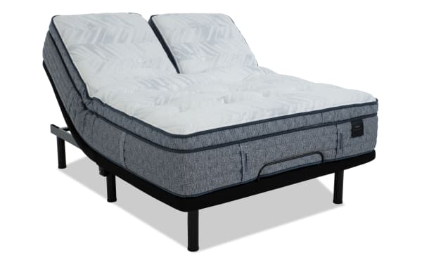 Adjustable split king bed with gray fabric base and white patterned mattress, featuring dual motor incline for customizable comfort.