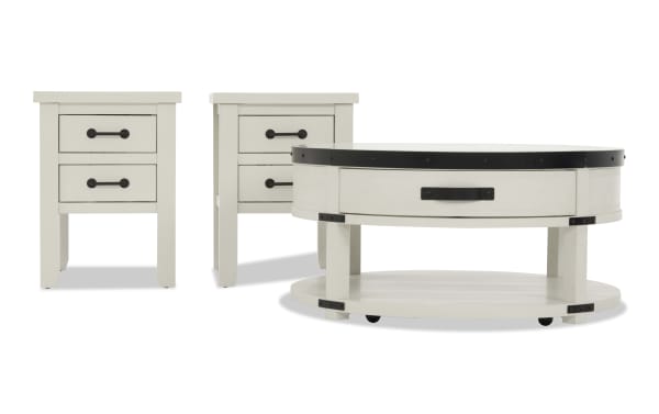 Set of white wooden furniture including two square side tables with black metal handles and one round coffee table with a black metal rim and lower shelf, featuring a rustic farmhouse style.