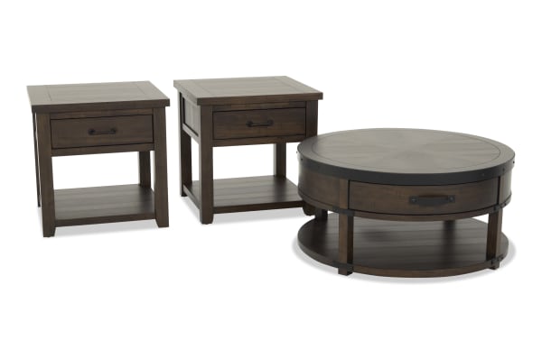 Set of three dark brown wooden living room tables including two square end tables and one round coffee table, all with metal handles and lower shelves.