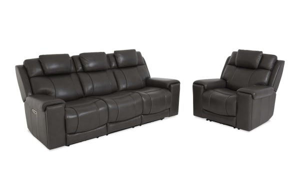 Dark gray leather reclining sofa set with three seats and matching single recliner chair, featuring padded armrests and headrests for living room comfort.