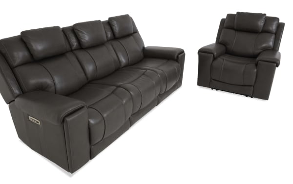 Dark gray leather reclining sofa and armchair set with padded cushions and armrests, featuring modern stitching and built-in control buttons.