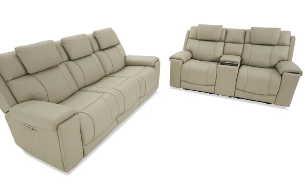 Beige leather reclining sofa set with plush cushioned backrests, padded armrests, and a center console with cup holders, designed for modern living rooms.