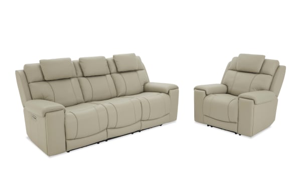 Beige leather reclining sofa set with three seats and matching single armchair, featuring padded armrests and headrests for living room comfort.