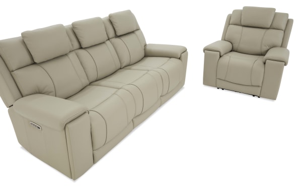 Beige leather reclining sofa and armchair set with padded cushions and armrests, featuring modern stitching and electric recline controls.
