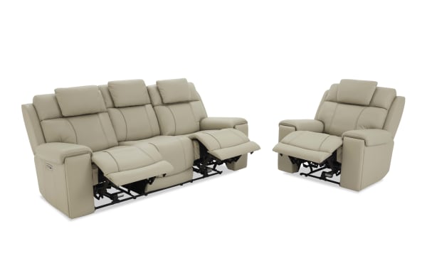 Beige leather reclining sofa and armchair set with padded armrests and adjustable footrests, designed for living room comfort and relaxation.