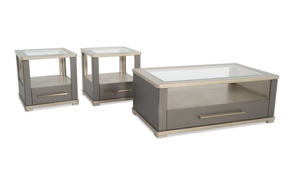 Set of modern gray leather and metal side tables and coffee table with glass tops and storage drawers, suitable for living room decor.