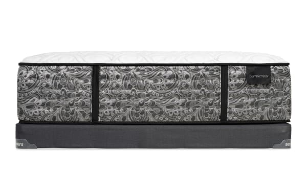 Mattress with a gray and white paisley pattern, black piping, and a white quilted top, labeled "DISTINCTION," on a dark gray fabric foundation with "BOB'S" branding.