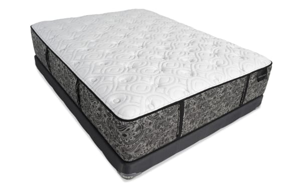 Queen-size mattress with white quilted top and gray patterned sides, featuring side handles and a dark gray foundation base.
