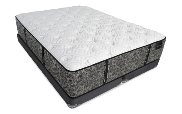 Mattress and box spring set with a white quilted top featuring circular patterns, gray floral sides, and black piping, branded "BOB'S" and "DISTINCTION."
