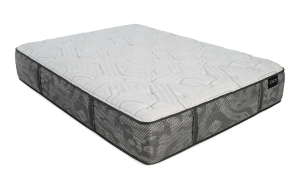 Mattress with a quilted white top and gray patterned sides, featuring side handles and a black label with the brand name "ZEUS."