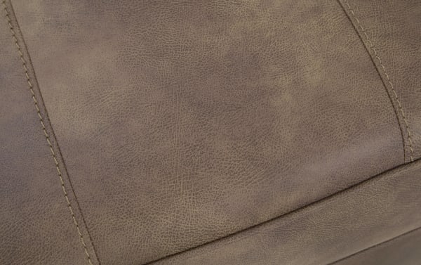 Brown leather upholstery with detailed stitching and a textured surface, highlighting durable and stylish furniture material.