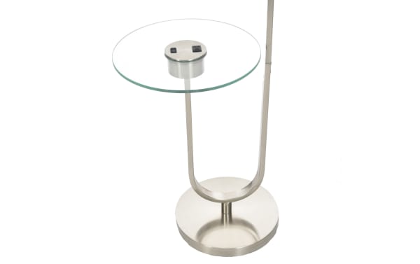 Modern side table with a round clear glass top and brushed metal base, featuring two black switches on the tabletop for built-in functionality.