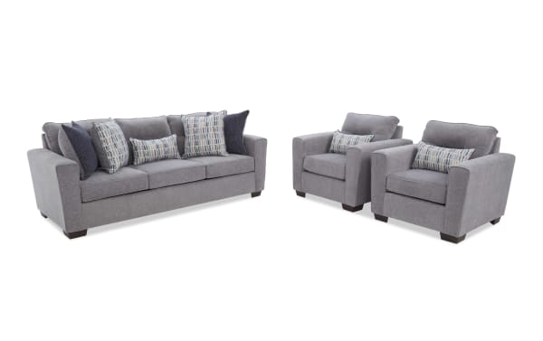 Gray fabric living room furniture set with a three-seater sofa and two armchairs, featuring dark wooden legs and patterned throw pillows.