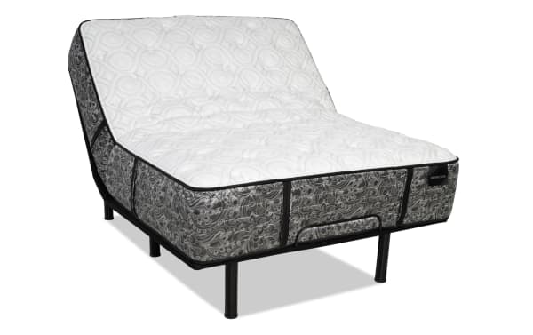 Adjustable bed base with black metal frame and paisley-patterned gray fabric sides, white quilted top, labeled "DISTINCTION" for enhanced comfort and support.