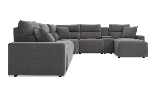 Large modern gray fabric sectional sofa with plush cushions, L-shaped design, and built-in armrest storage compartment, ideal for spacious living rooms.