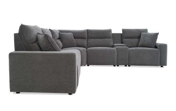 Modern L-shaped sectional sofa in dark gray fabric upholstery with plush cushions, wide armrests, and a built-in console for storage or cup holders.