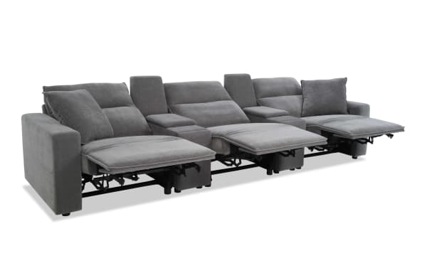 Modern gray fabric reclining sectional sofa with three seats, adjustable footrests, padded armrests, and plush cushions for living room comfort.