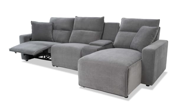 Gray fabric sectional sofa with reclining seat and chaise lounge, featuring plush cushions and a modern design for living room comfort.