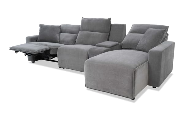 Modern gray fabric sectional sofa with reclining seat and chaise lounge, featuring plush cushions and padded armrests for enhanced comfort.