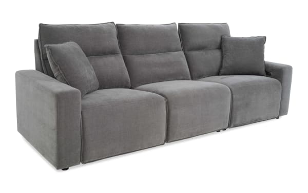 Modern gray fabric reclining sofa with three seats, plush back cushions, and two matching throw pillows, ideal for living room comfort.