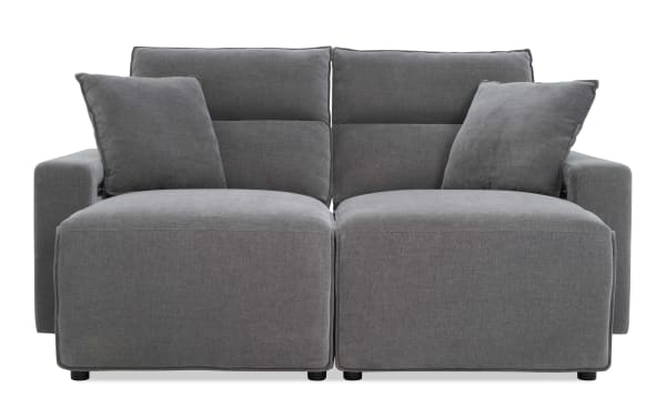 Modern gray fabric loveseat with plush cushions, wide armrests, and a minimalist design, ideal for contemporary living rooms.
