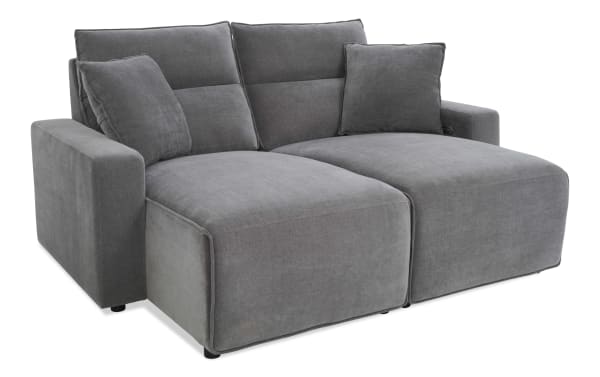 Modern gray fabric sectional sofa with plush cushions, wide armrests, and chaise lounge, designed for comfortable living room seating.