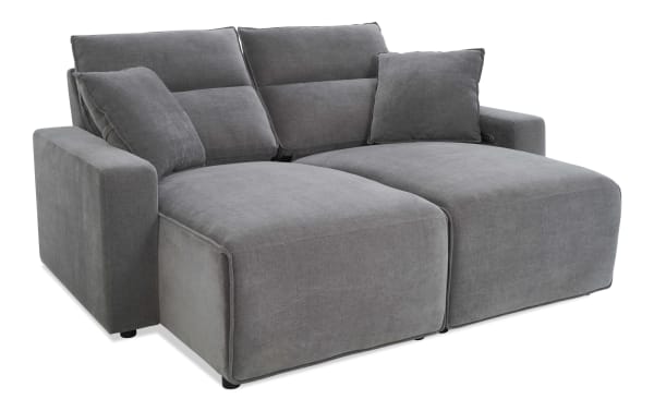 Modern gray fabric sectional sofa with plush cushions, wide armrests, and a chaise lounge for comfortable seating in living rooms.