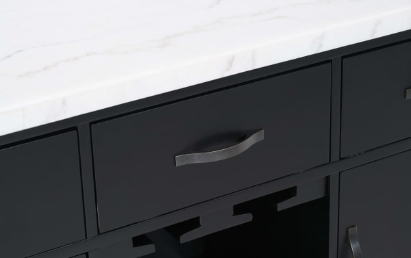 Dark matte black kitchen cabinet drawer with a curved metal handle below a white marble countertop, showcasing modern cabinetry design.