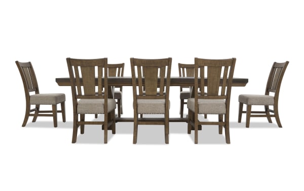 Dining set with a rectangular dark wood table and eight matching wooden chairs with beige upholstered seats and nailhead trim.