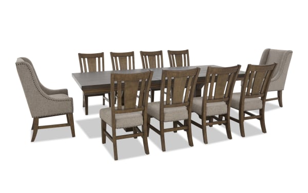 Dining set with a large rectangular dark wood table and ten chairs, featuring eight wooden chairs with beige upholstered seats and two beige fabric wingback armchairs with nailhead trim.