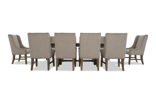 Dining set with a rectangular wooden table and ten beige upholstered chairs featuring nailhead trim and wooden legs, suitable for formal dining rooms.
