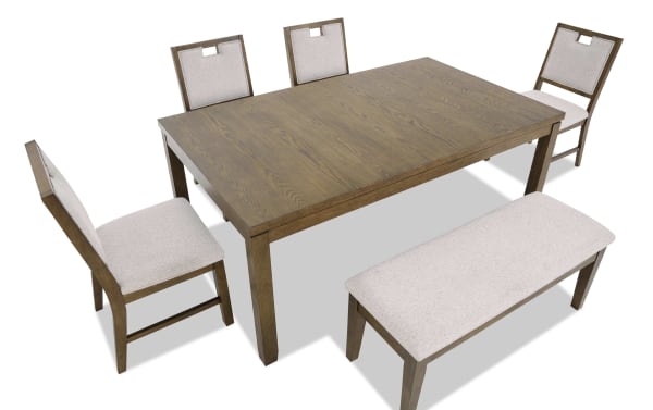 Wooden dining table set with a rectangular oak finish table, four beige upholstered chairs with cutout handles, and a matching bench.