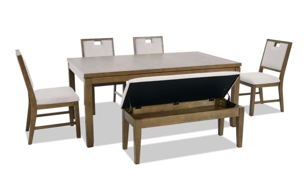 Dining set with a rectangular wooden table, four beige upholstered chairs, and a storage bench with lift-up cushioned seat in light wood finish.