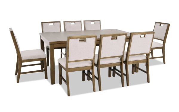Wooden dining table set with eight beige upholstered chairs, featuring a modern design with cutout handles on chair backs, ideal for family meals.