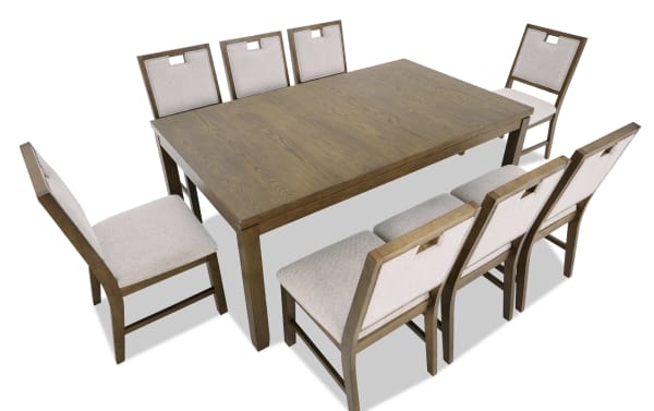 Rectangular wooden dining table with a natural oak finish, paired with eight cushioned chairs featuring beige fabric upholstery and wooden frames.