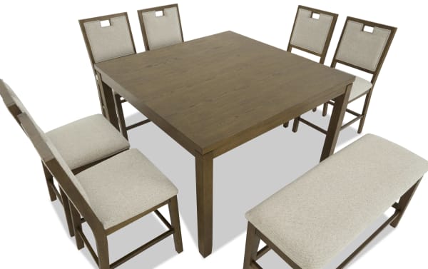 Wooden dining table set with six beige upholstered chairs and a matching bench, featuring a square tabletop and sturdy legs.