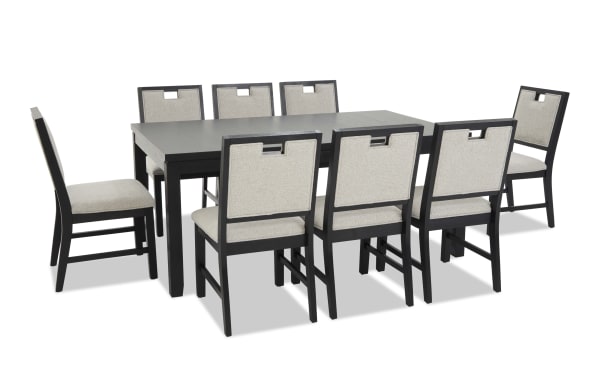 Modern black wooden dining table set with eight beige upholstered chairs, featuring cushioned seats and backrests, ideal for contemporary dining rooms.