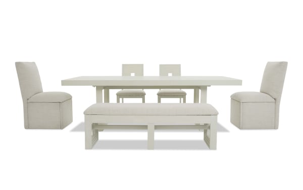 Modern white dining set featuring a rectangular table, two upholstered side chairs, two wooden back chairs, and a cushioned bench with fabric seats.
