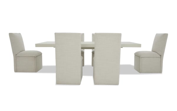 Modern dining set with six beige upholstered chairs and a rectangular light gray table, featuring a minimalist and contemporary design.
